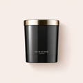 Vonná svíčka Jo Malone Myrrh & Tonka se zlatým víčkem na béžovém pozadí – MrRizz